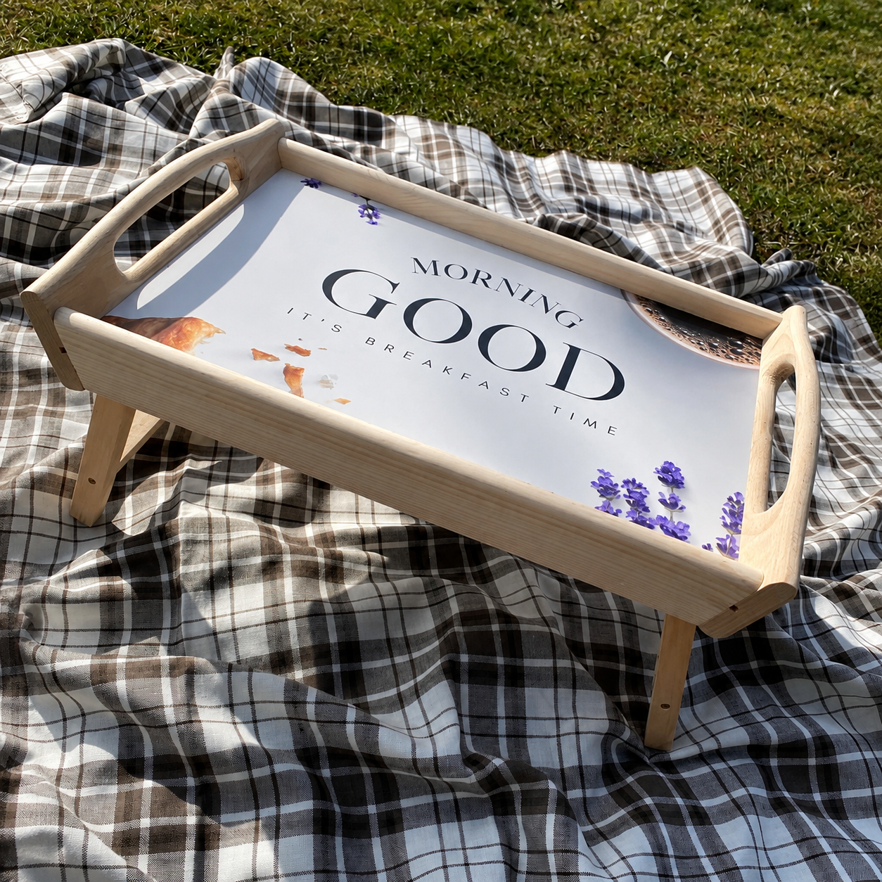 Handmade wooden breakfast tray with folding legs on picnic blanket in natural sunlight