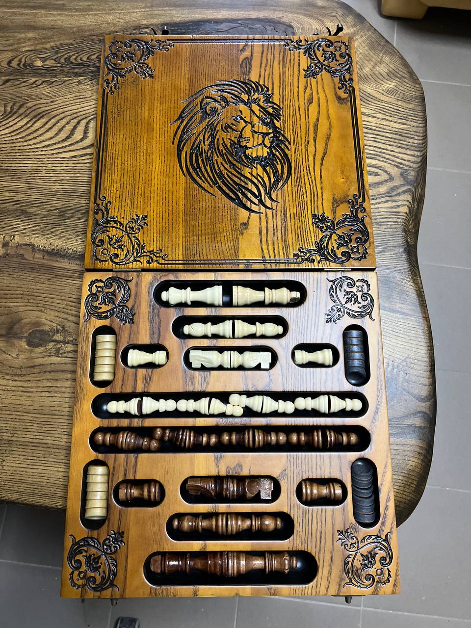 Inside view of wooden chess and checkers set with carved ash board, lion engraving, resin chess pieces and checkers stored inside