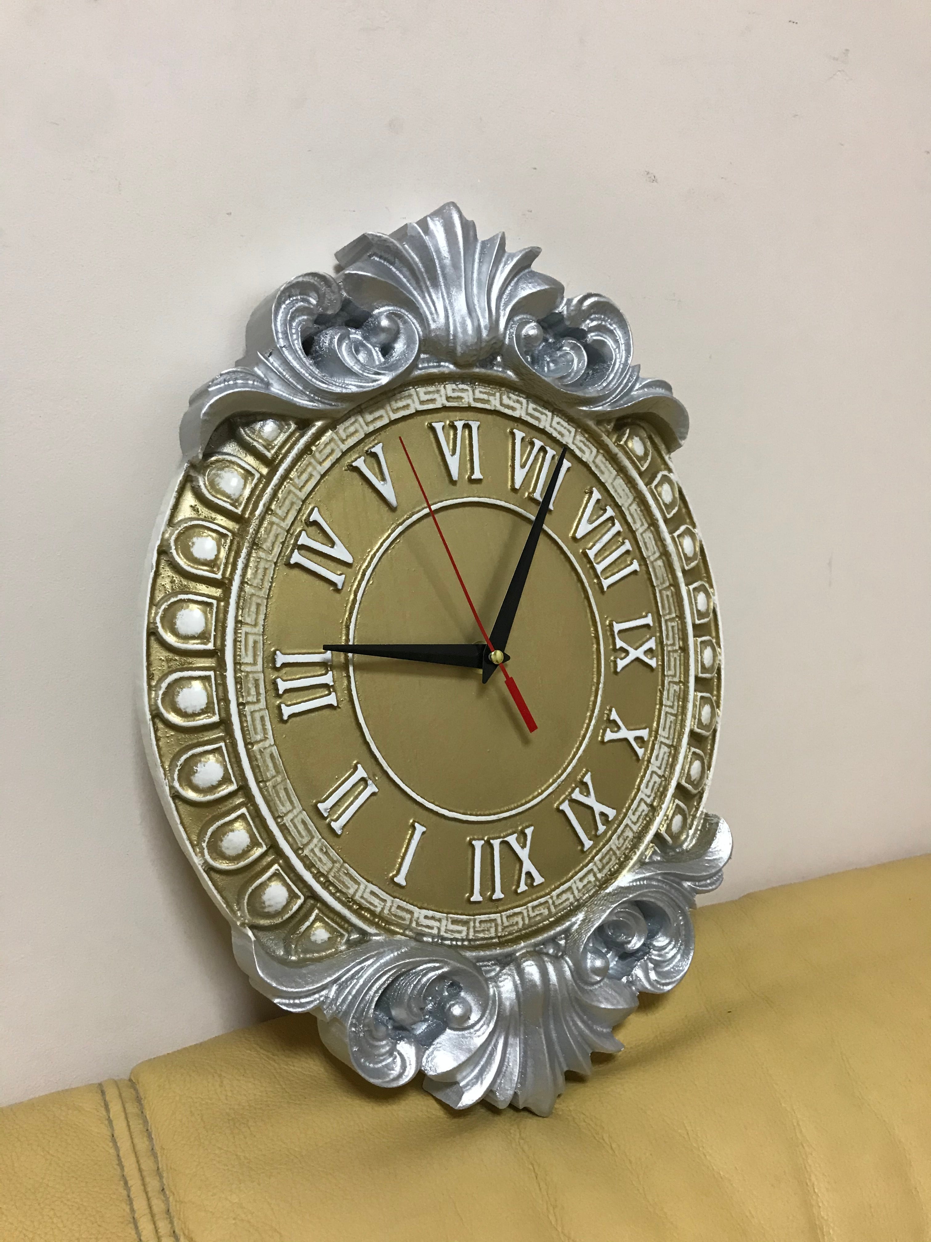 Baroque wall clock with Roman numerals shown at angle, gold dial and silver carved frame decorative home clock