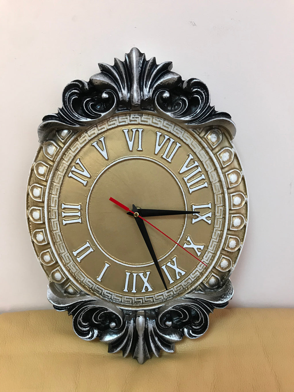 Classic baroque wall clock with Roman numerals in silver and gold tones, decorative oval wooden wall clock