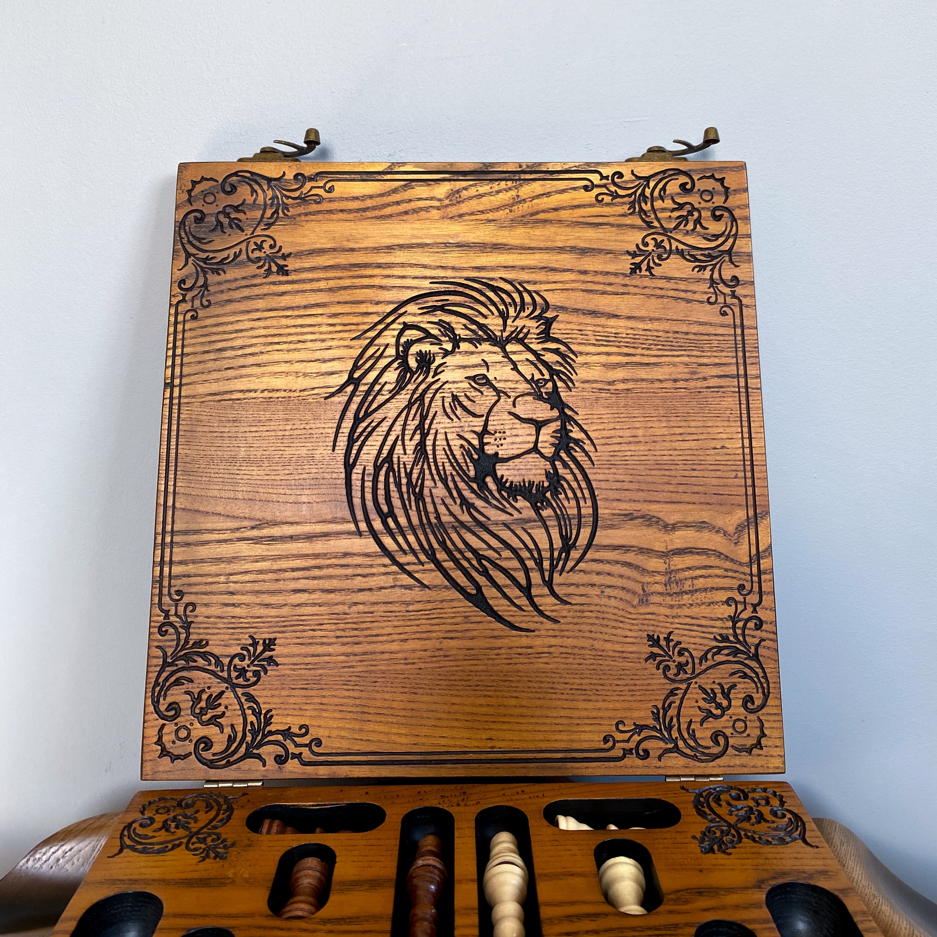 Carved lion artwork on wooden chess and checkers board lid