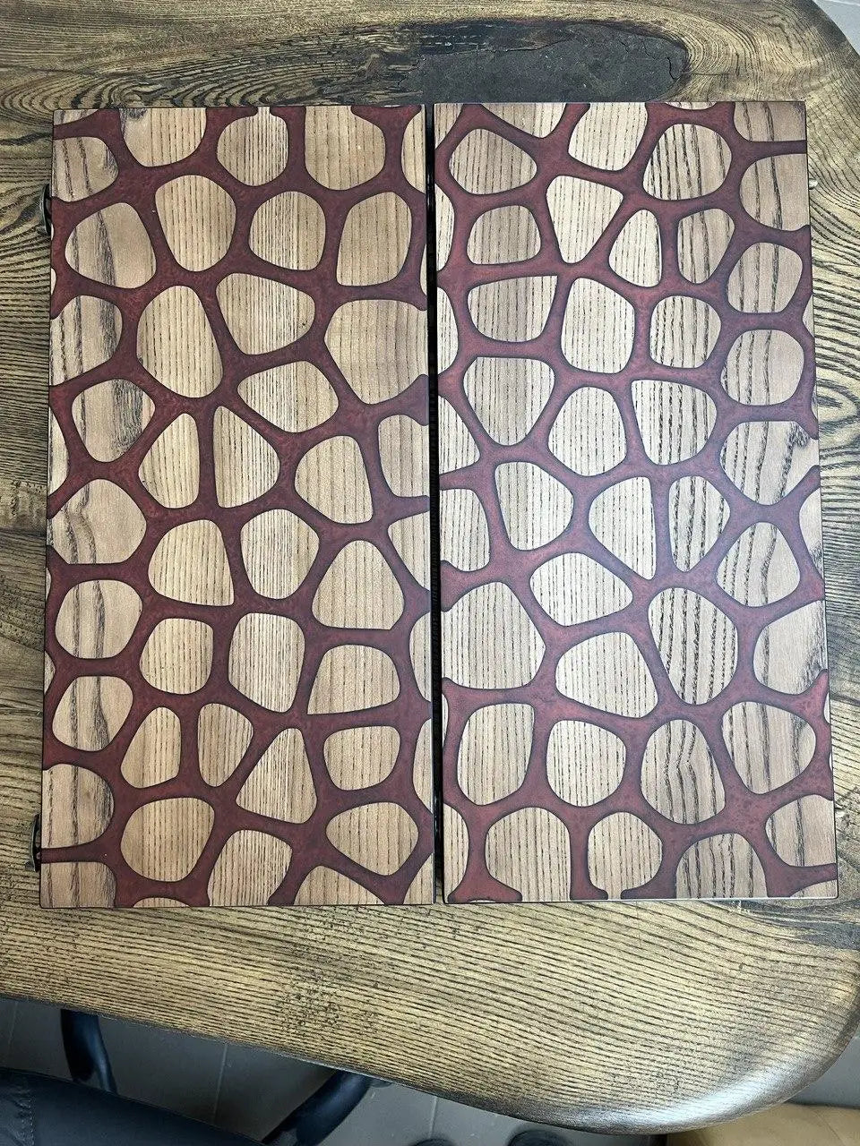 Open wooden backgammon game featuring red giraffe abstract artwork