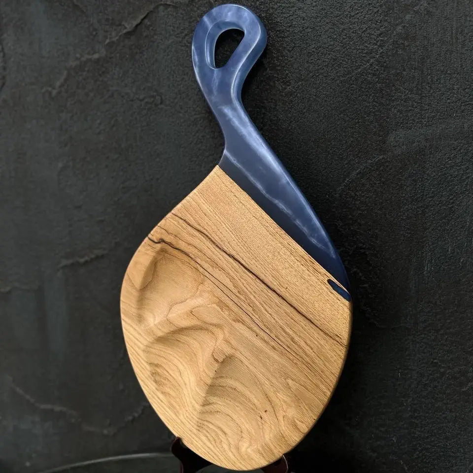 Wooden serving board with integrated blue epoxy resin handle for cheese and appetizers