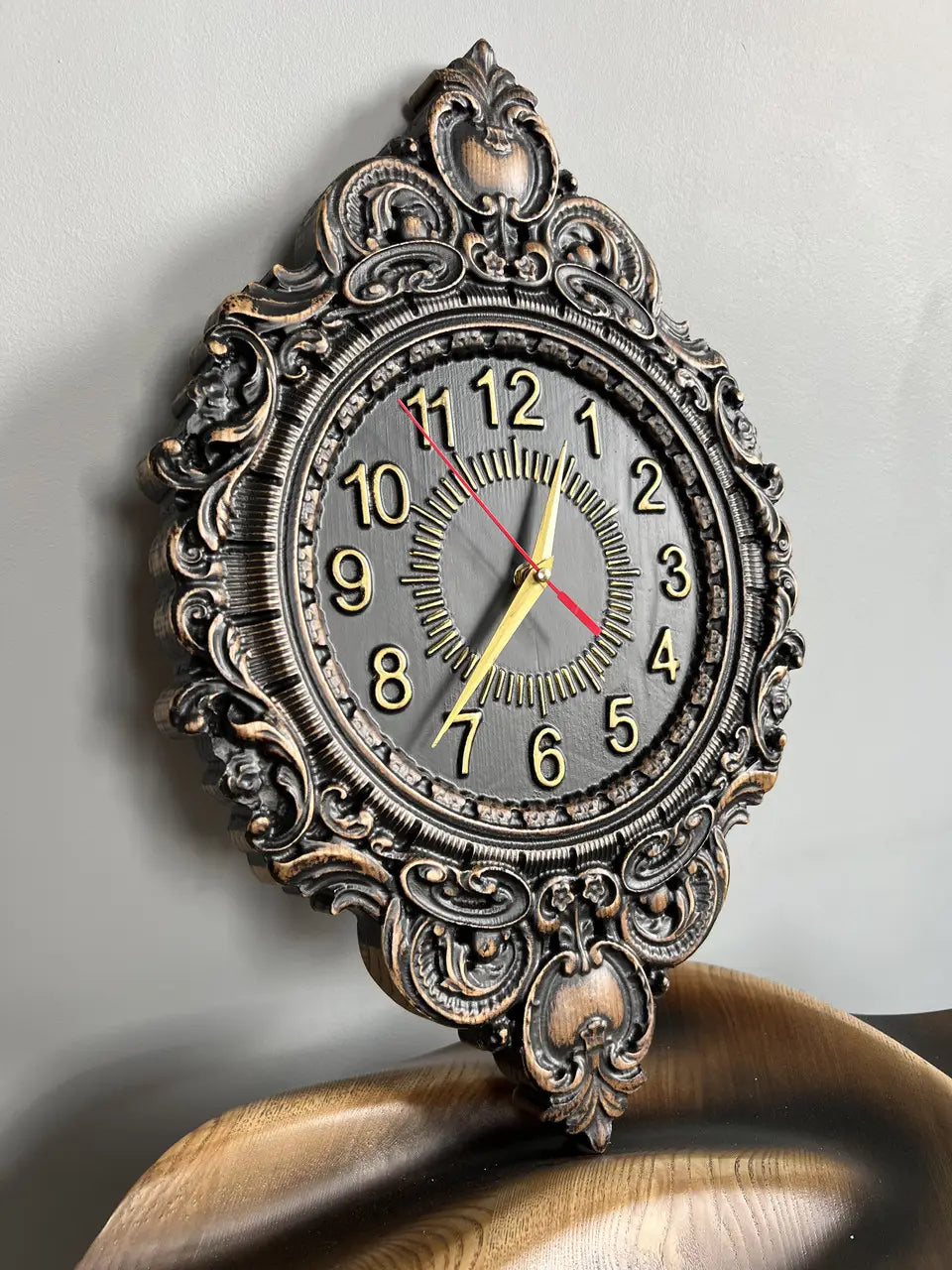 Close-up of carved ash wood wall clock showing detailed ornamental wood carving