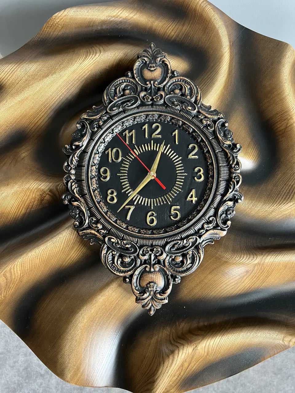 Luxury oval wooden wall clock with Roman numerals and gold hands on black face