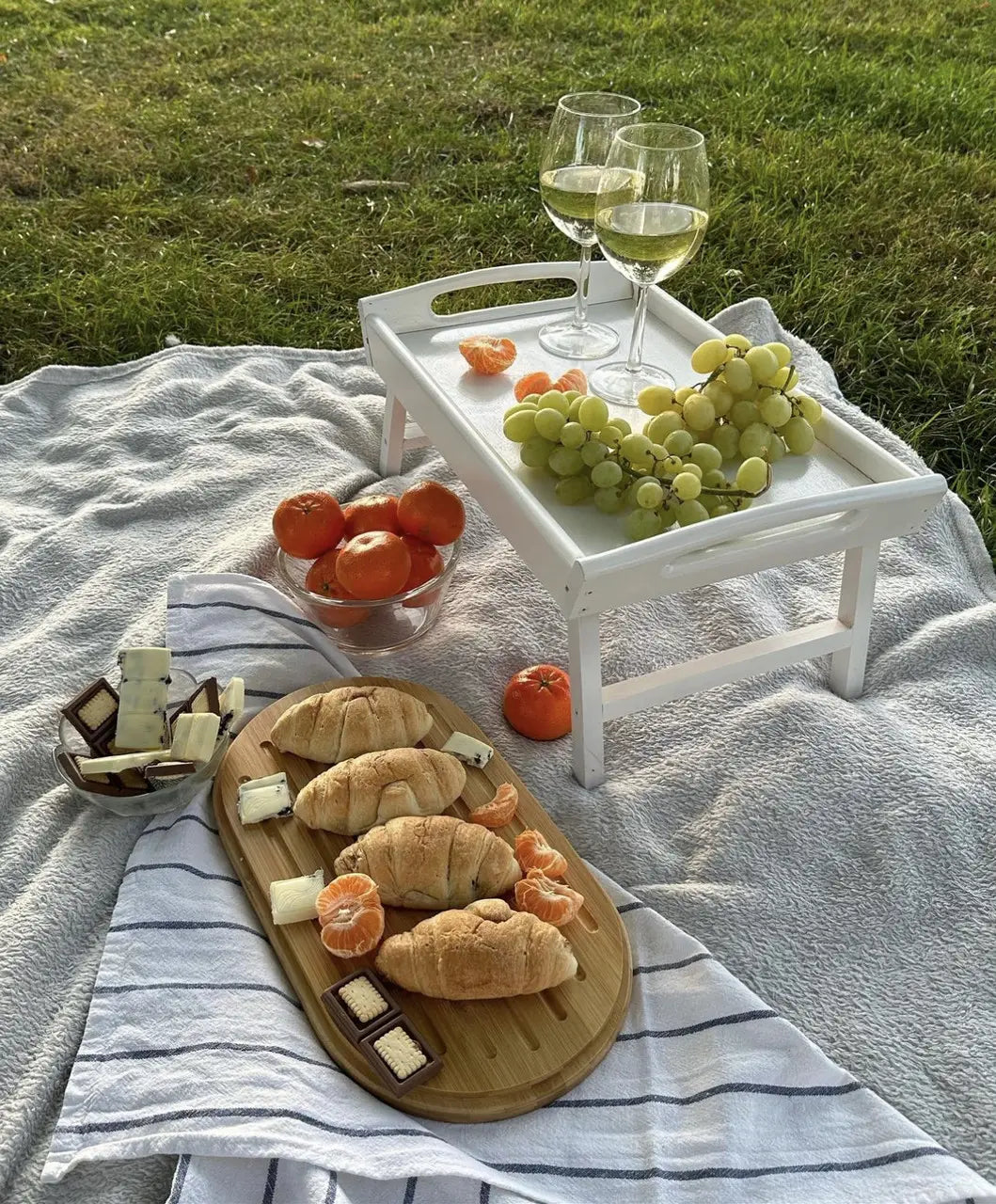 Foldable white wooden serving tray on grass outdoors
