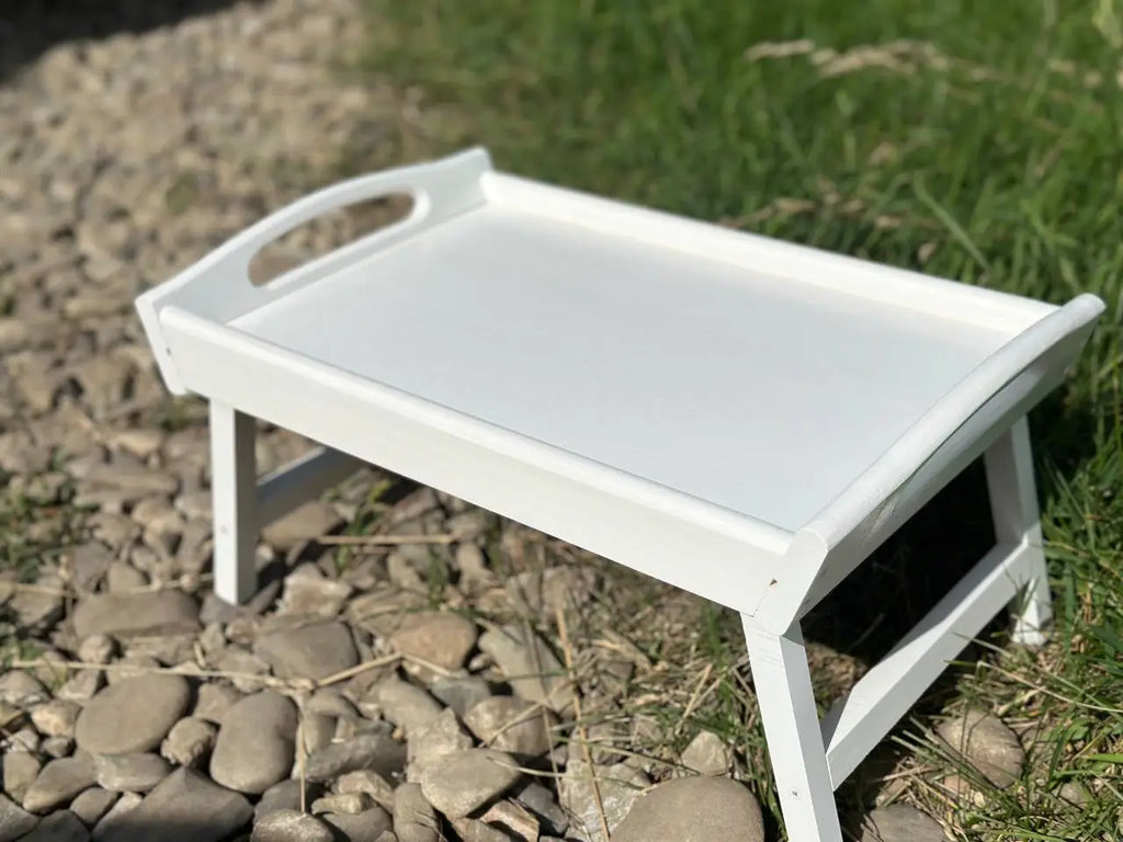 Stacked white wooden trays with foldable legs