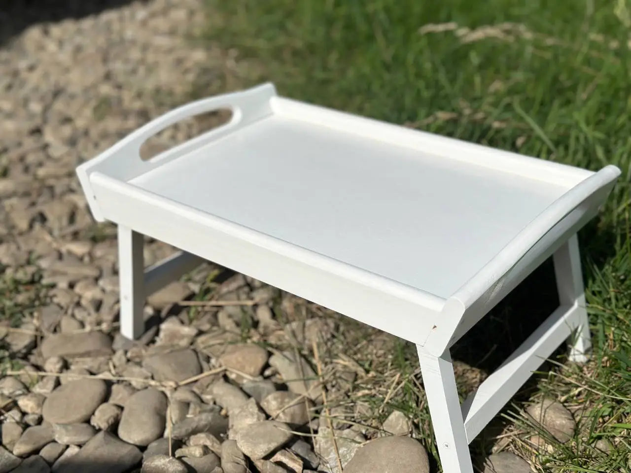 Stacked white wooden trays with foldable legs