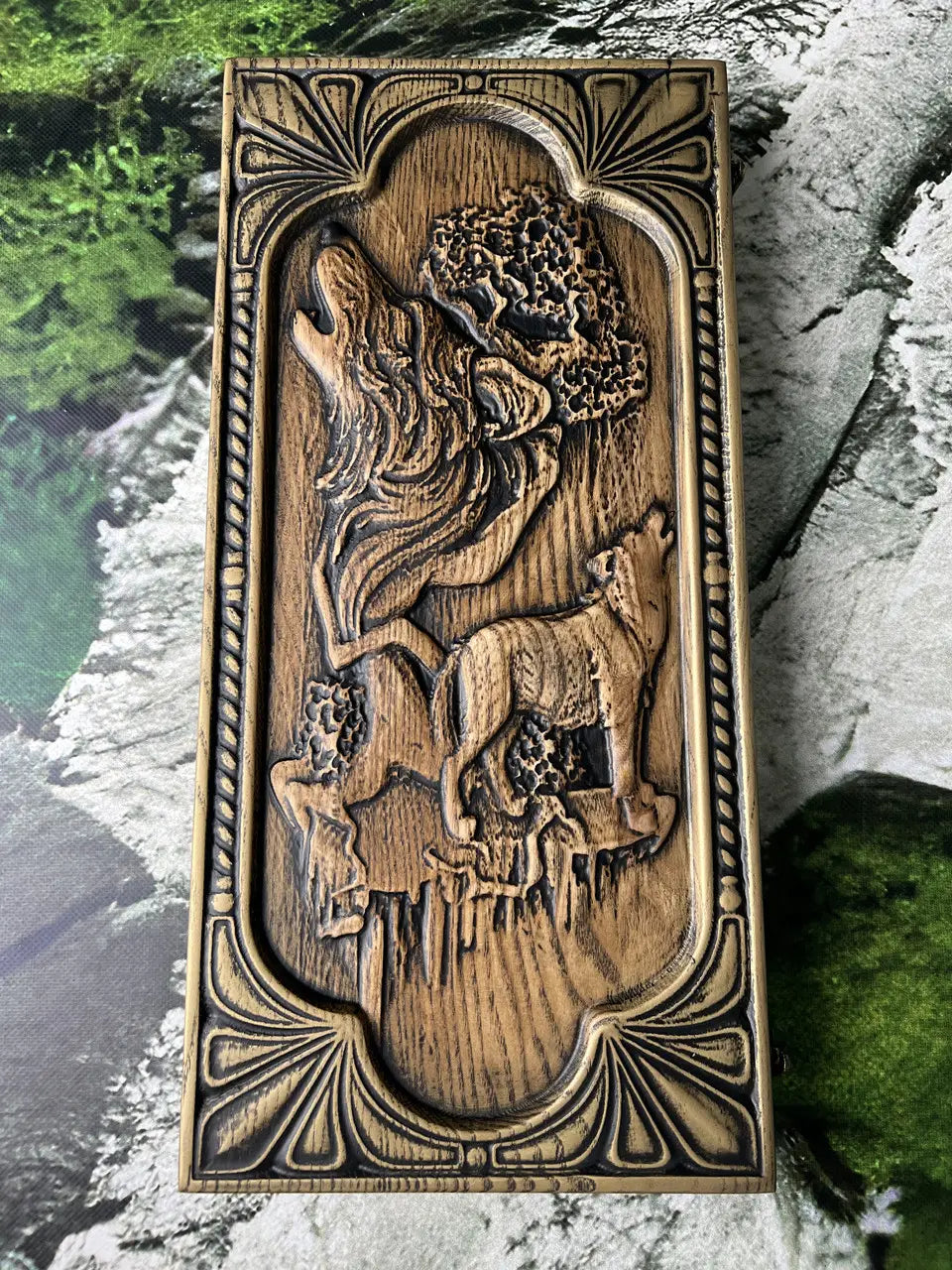 Close-up of carved wolf family artwork on wooden backgammon case