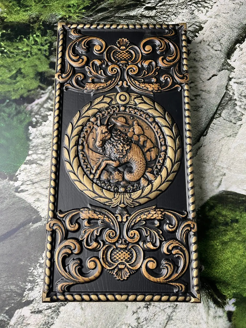 Detailed carving of the Capricorn zodiac sign on a wooden backgammon case