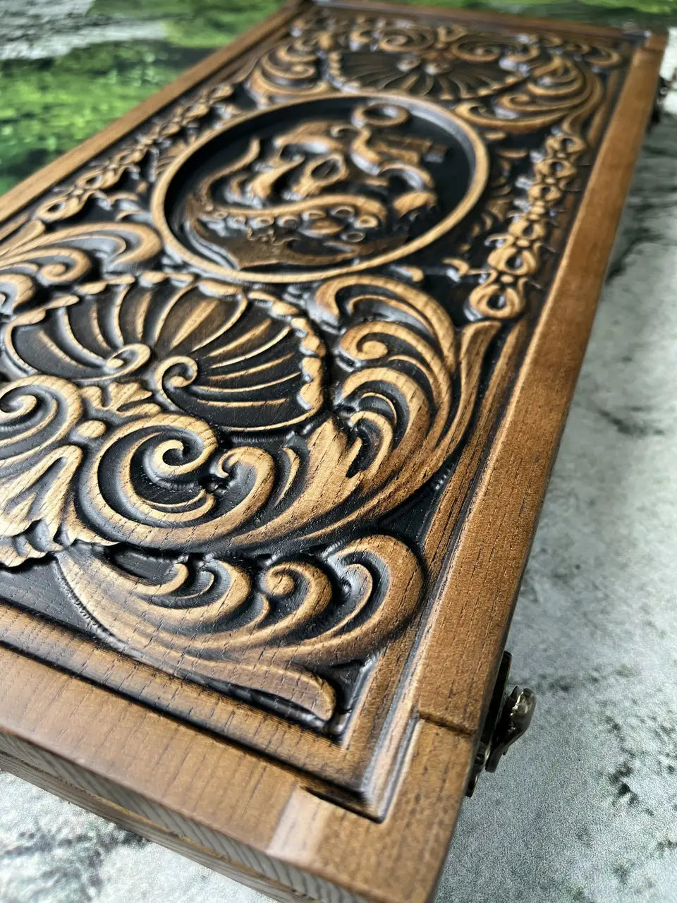 Close-up of wooden backgammon board with Kraken and skull carving
