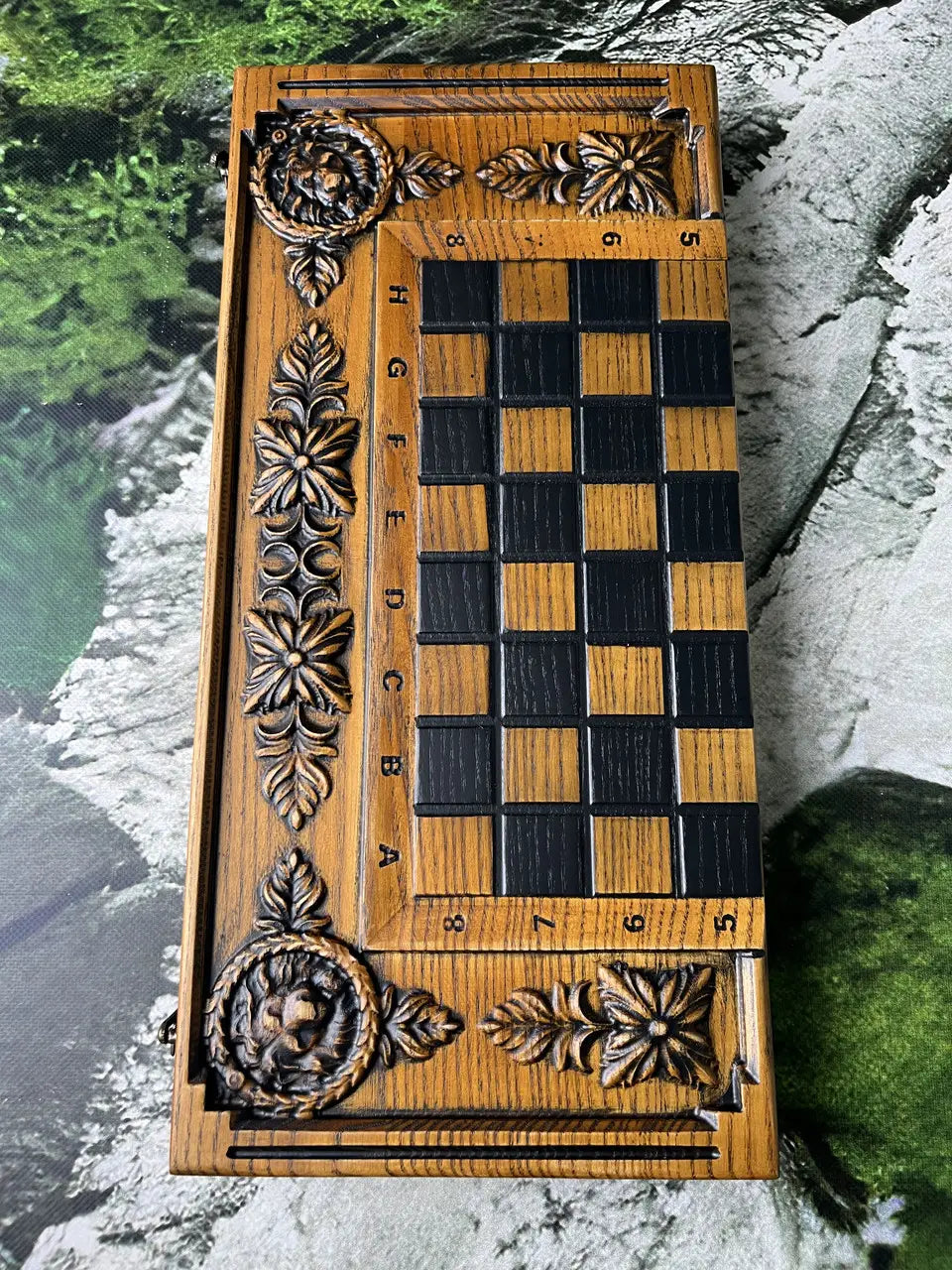 Wooden chessboard with carved frame and contrasting black and natural wood squares, handmade luxury board