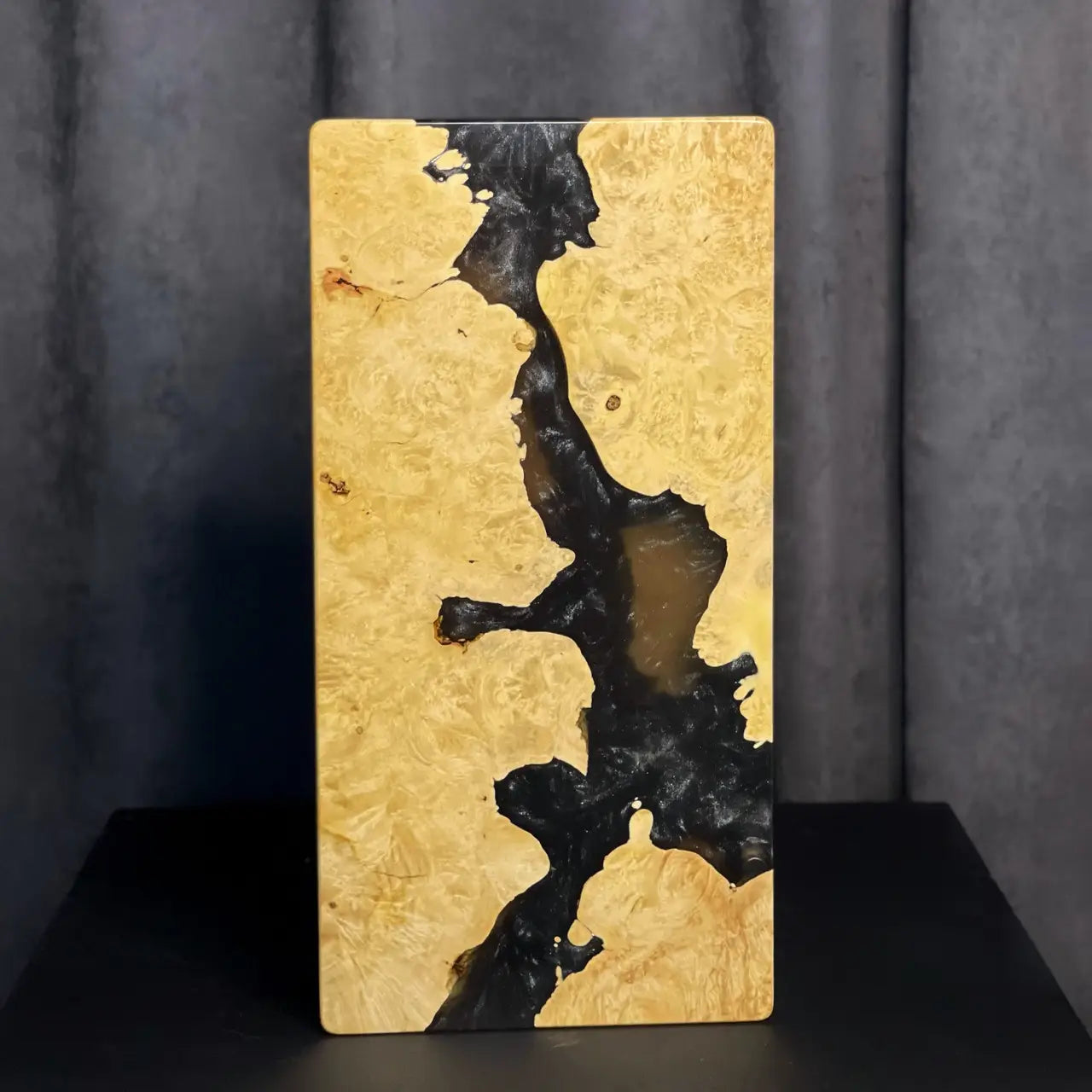 Close-up of burl wood and black pearlescent epoxy on backgammon set
