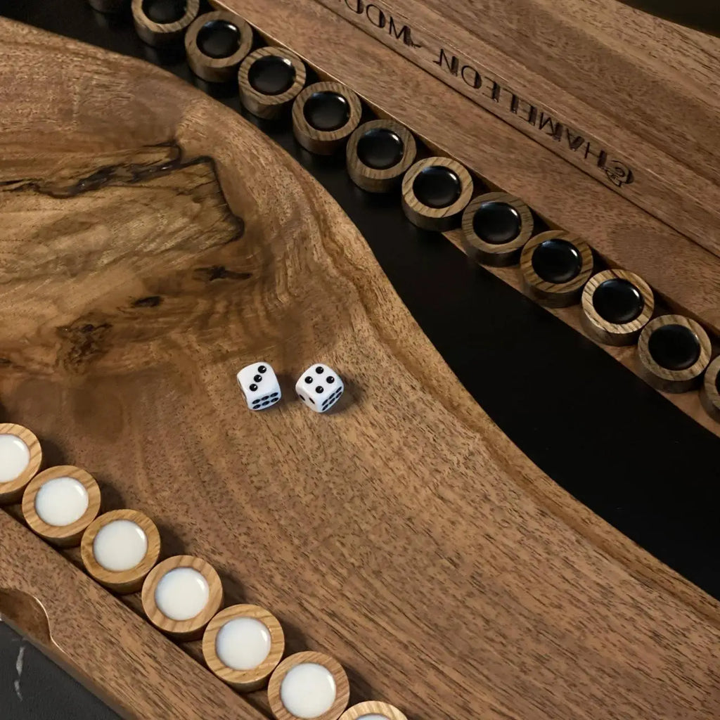 Close-up of wooden backgammon checkers and dice on American walnut playing board