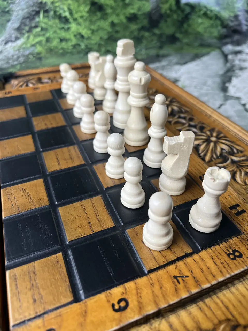 Handcrafted wooden chess pieces in white color on carved wooden chess board