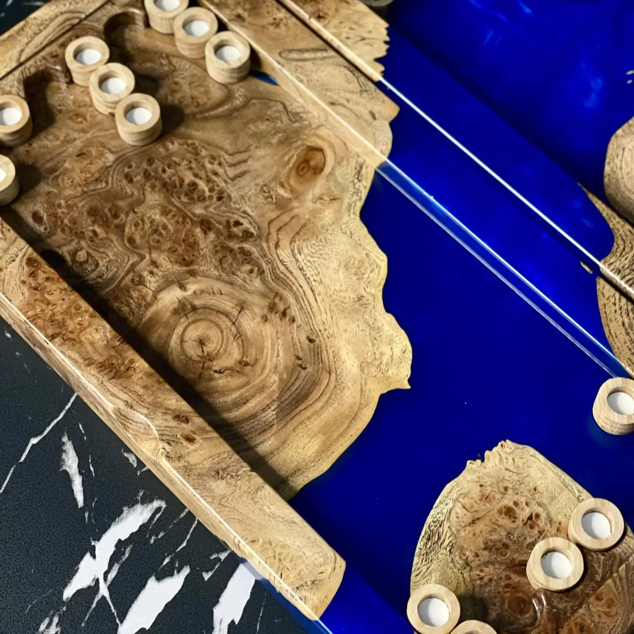 Close-up of handcrafted burl wood and sapphire epoxy backgammon board