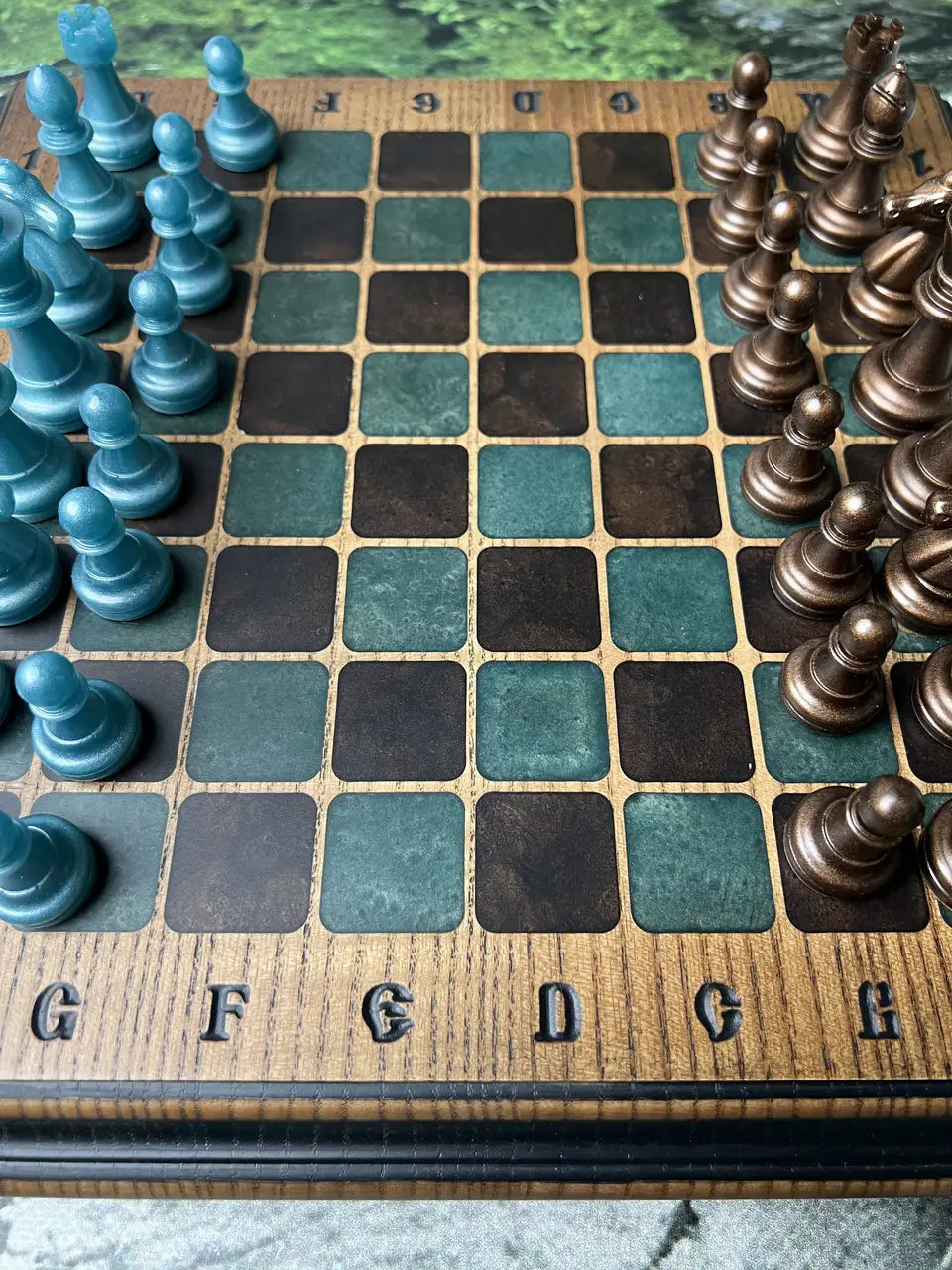 Luxury chess board detail showing green and dark squares with resin chess pieces