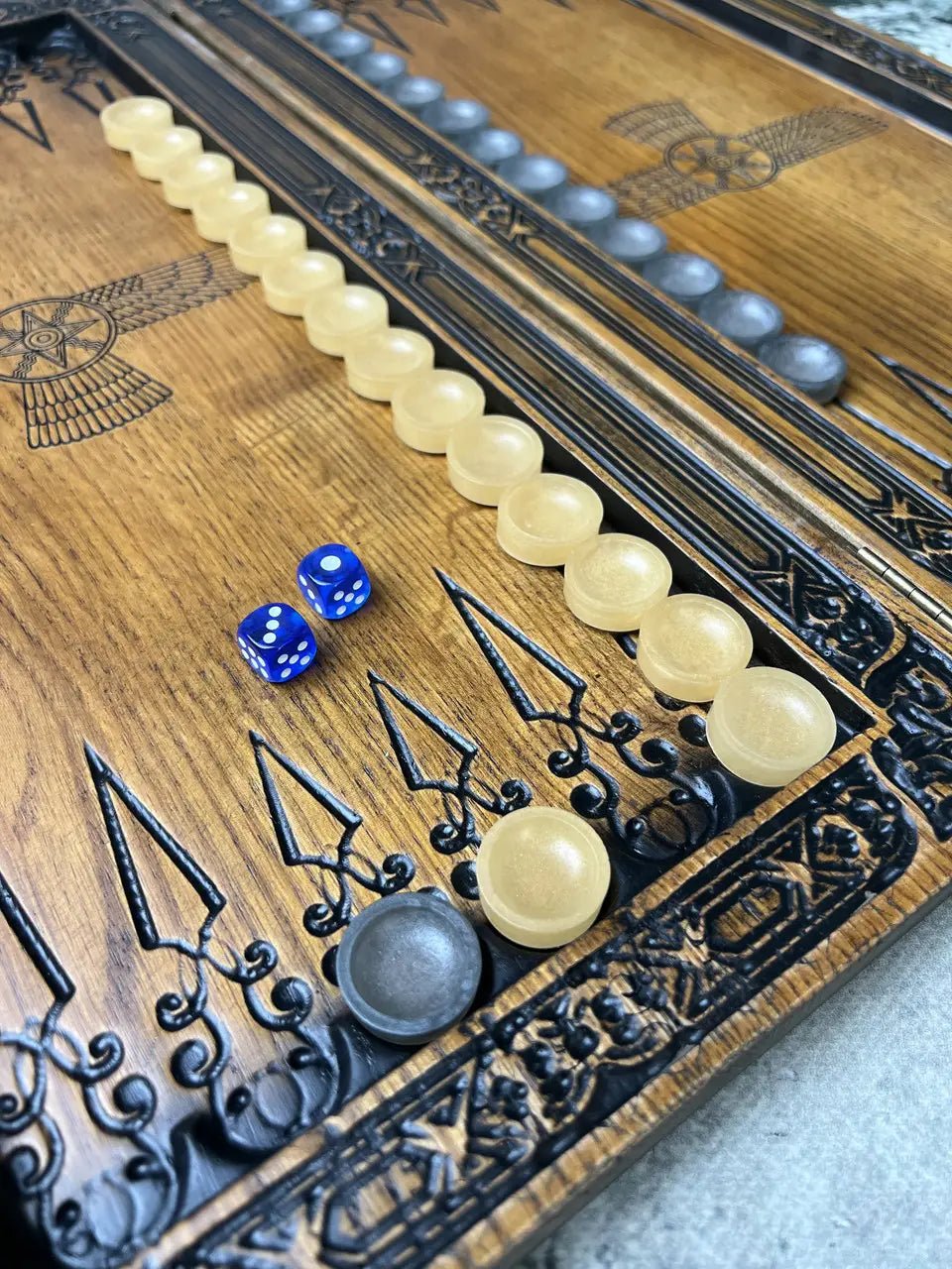 Detailed carving of the Shedu design on ash wood