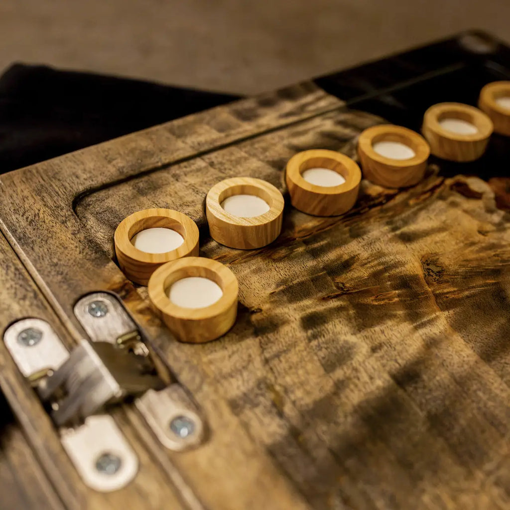Light wooden checkers on handcrafted Obsidian backgammon playing field