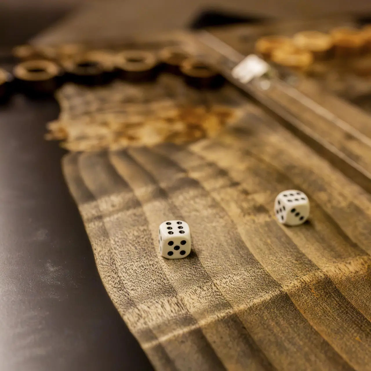 Dice on handcrafted natural wood and black epoxy backgammon board