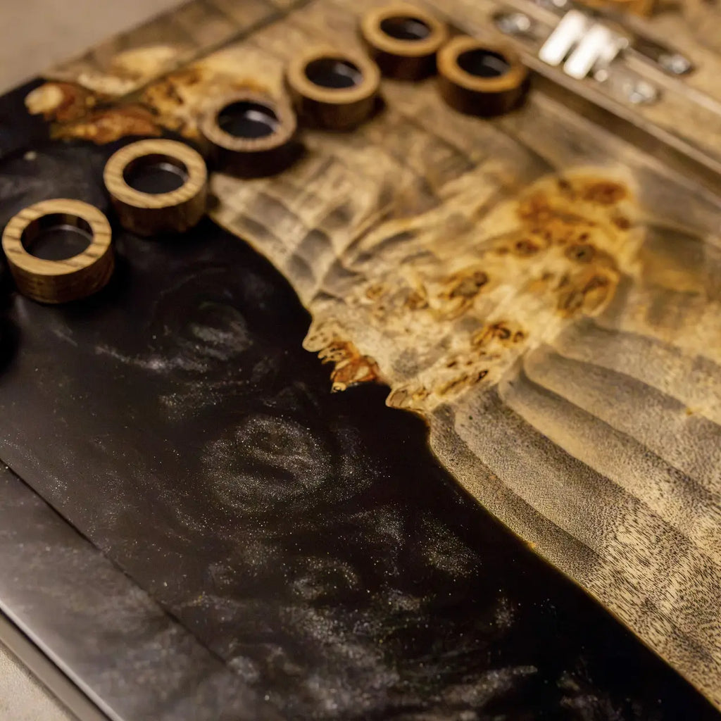 Handcrafted wooden checkers on black epoxy resin backgammon board
