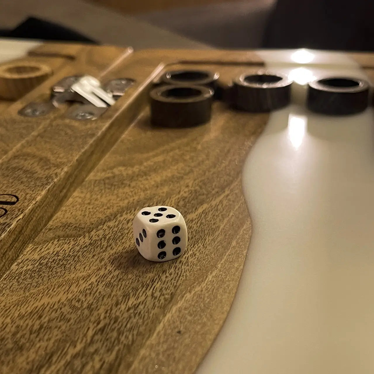 Close-up of dice on handmade wood and white resin backgammon board