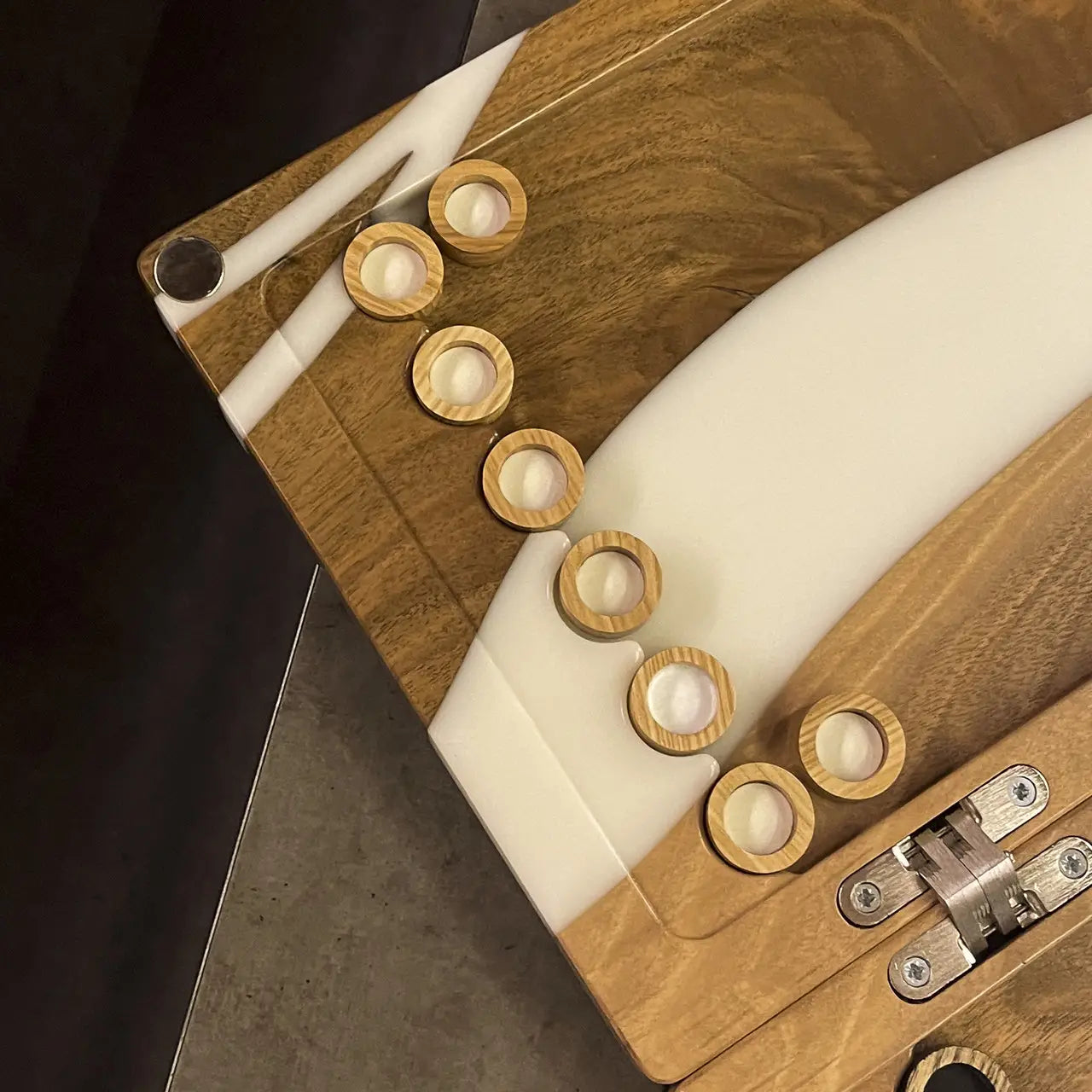 Light wooden checkers on white epoxy resin backgammon playing field
