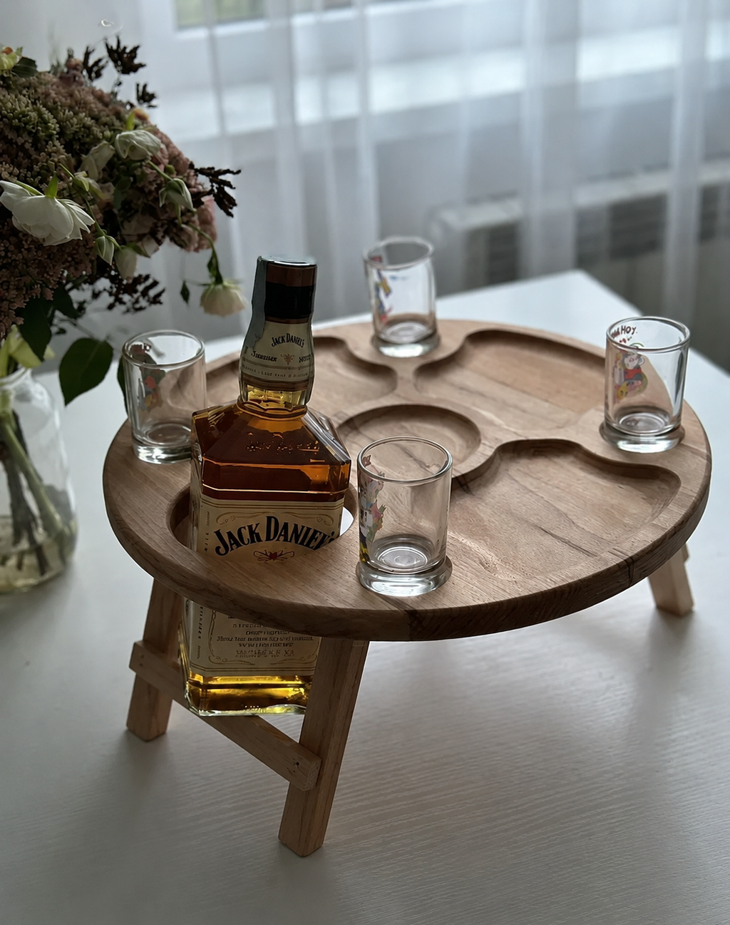 Round wooden snack table with foldable legs and compartments for appetizers