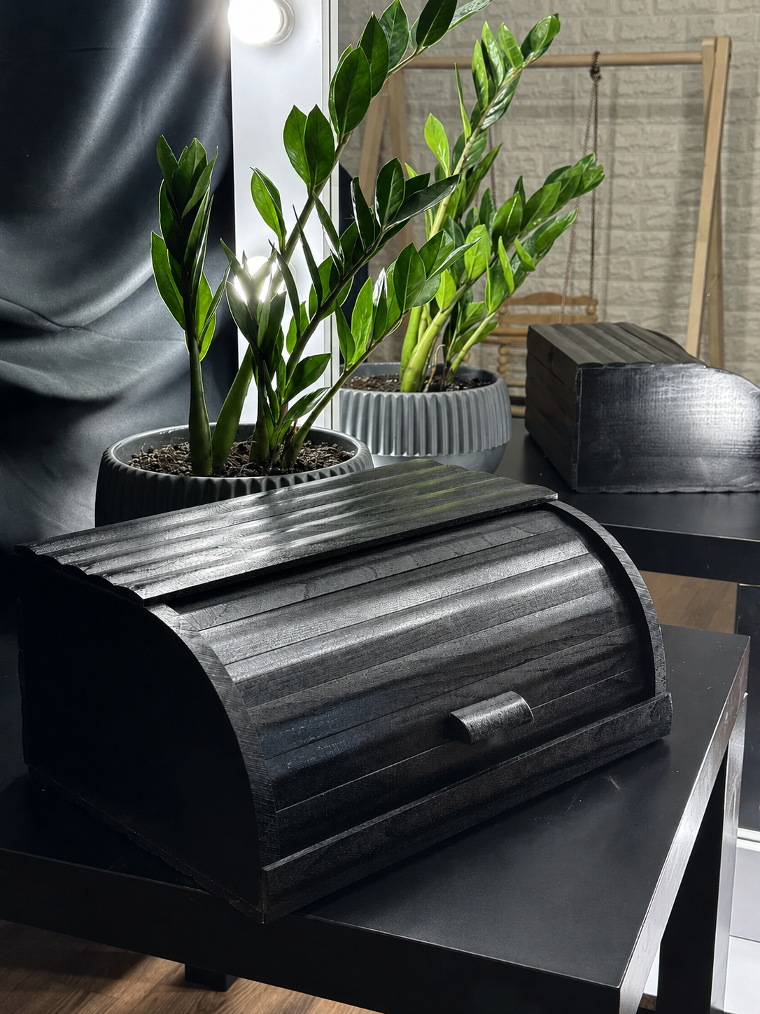 Black wooden roll-top bread box on modern kitchen countertop