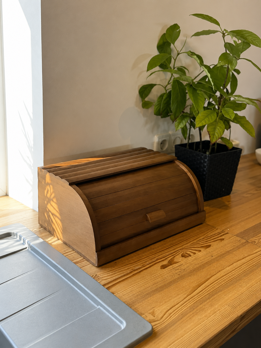 Handmade brown beech wood bread box on kitchen countertop