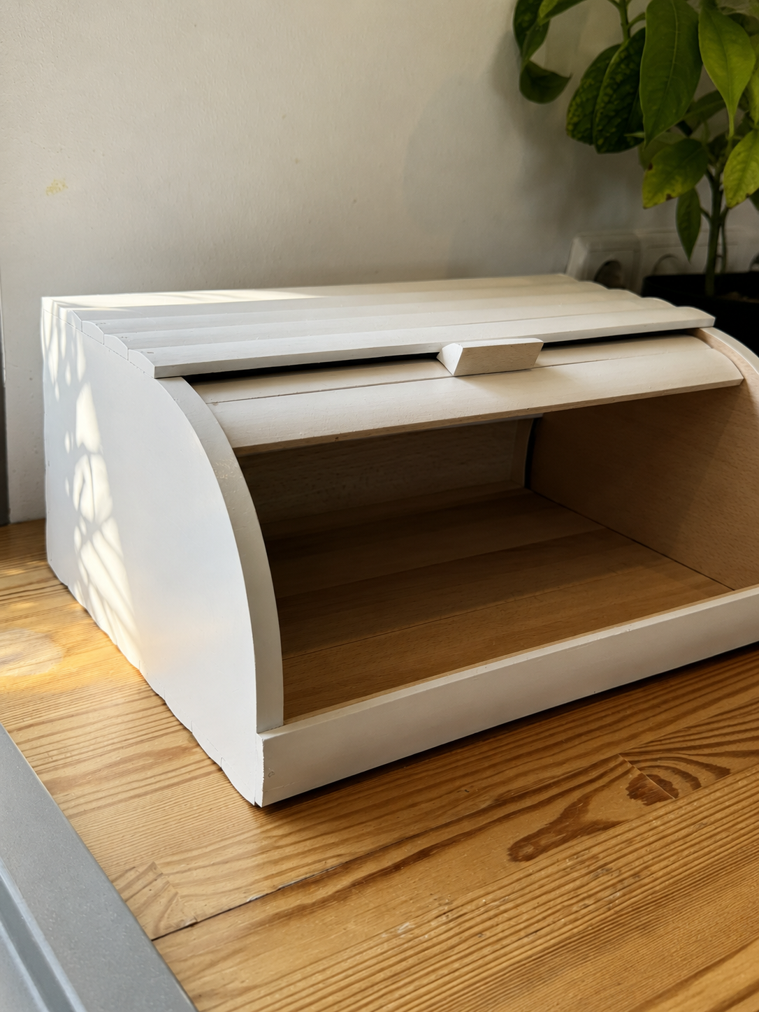 Wooden bread bin with spacious interior and roll-top design
