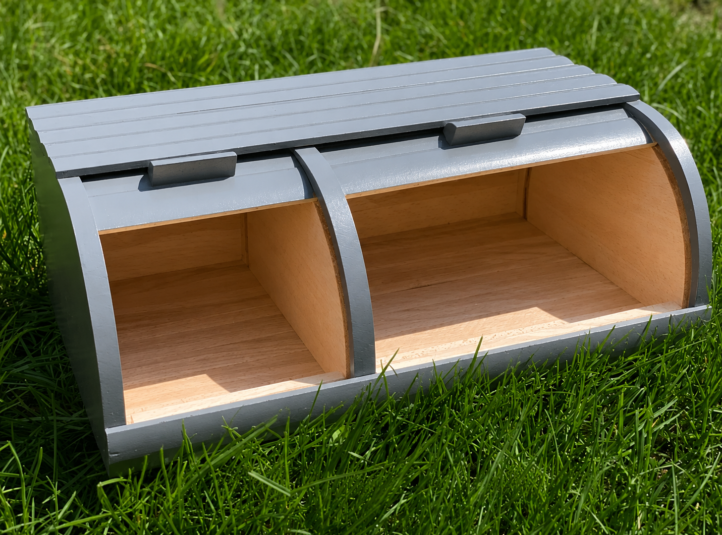 Gray double wooden bread box handmade from beech wood on green grass
