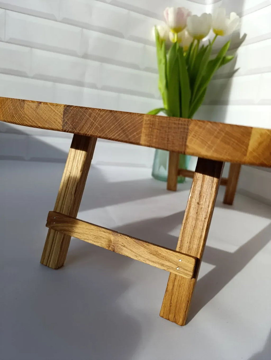 Focus on the solid wood legs of the tray table, highlighting quality joinery and rustic finish.
