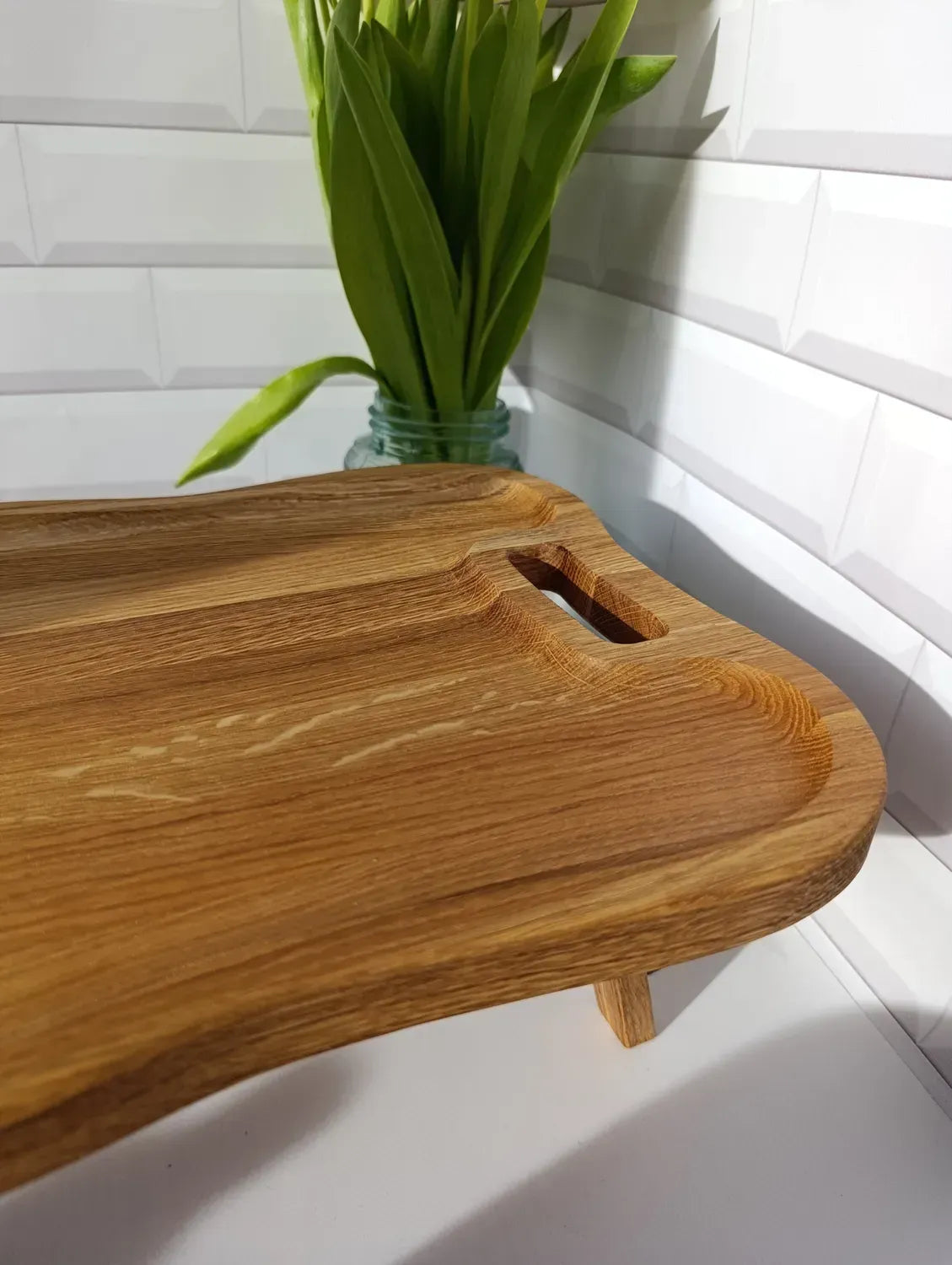 Close-up of a wooden tray’s smooth corner and handle, showing natural wood grain and fine craftsmanship.