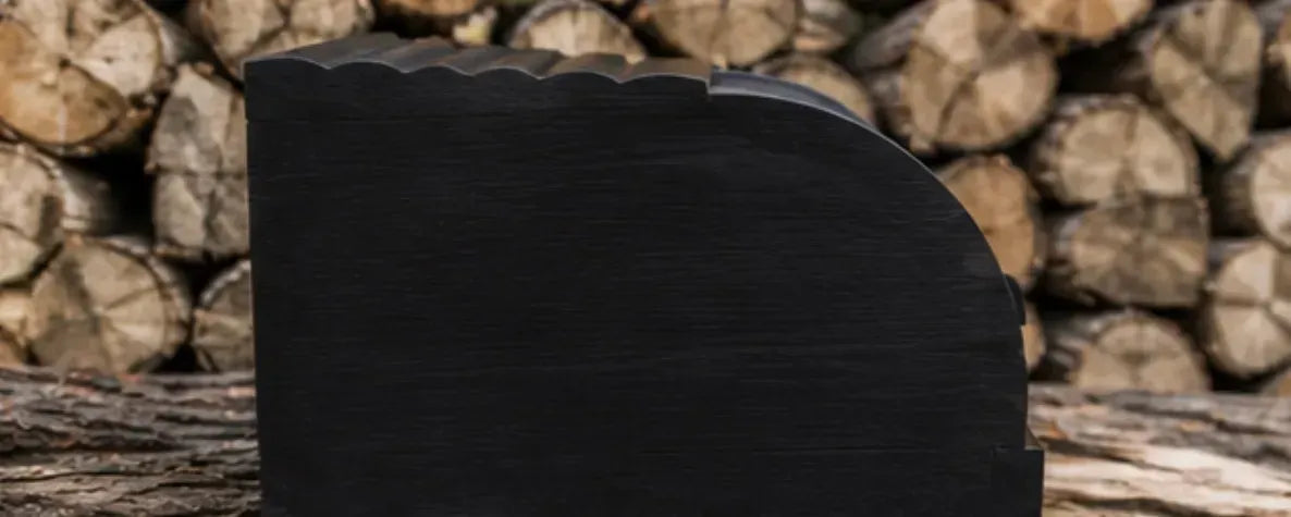 Elegant black wooden bread bin displayed on stacked firewood outdoors