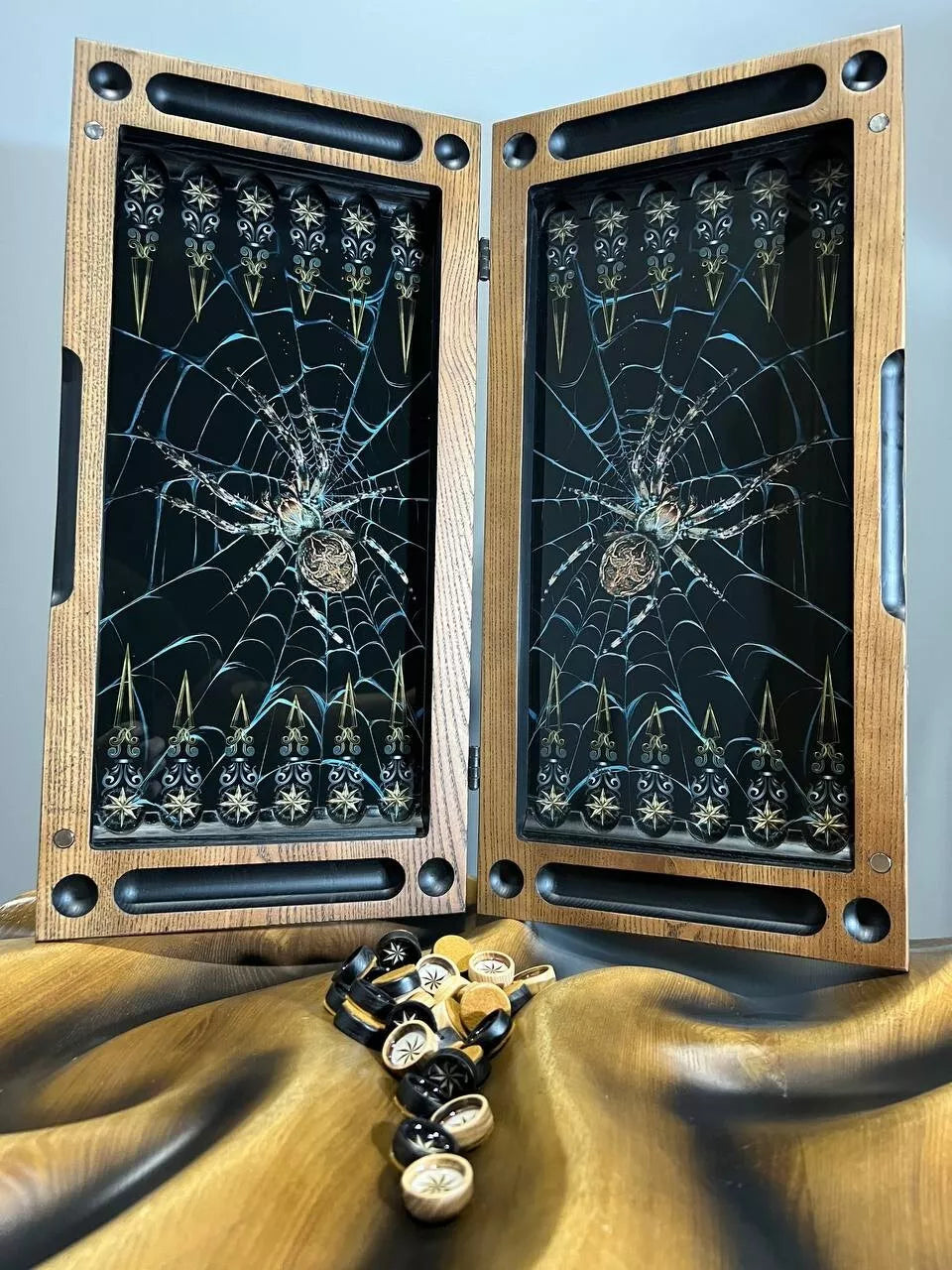 Handcrafted wooden backgammon board interior featuring dark spider web artwork and classic layout