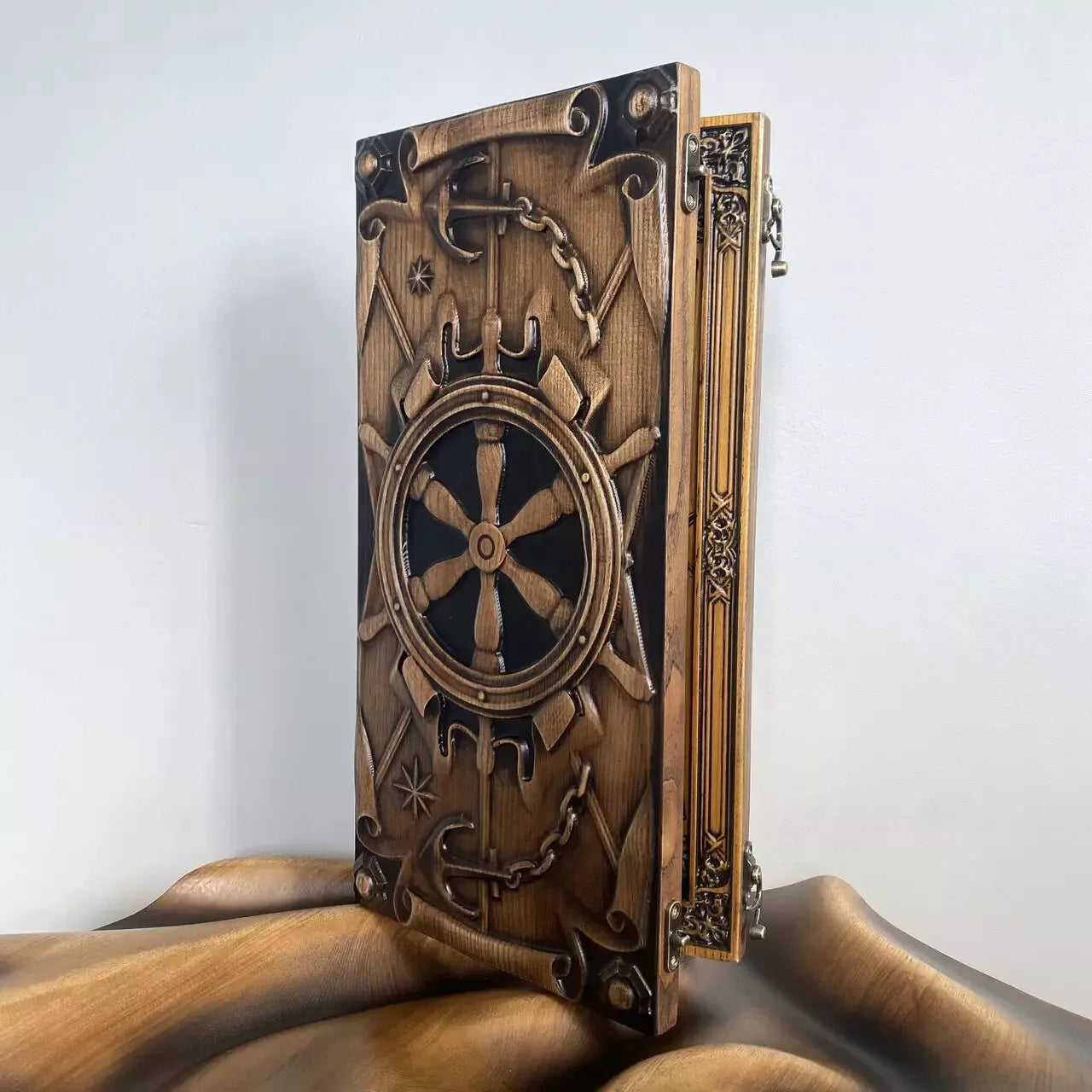 Handcrafted nautical backgammon board featuring a detailed ship wheel engraving and anchor motif.