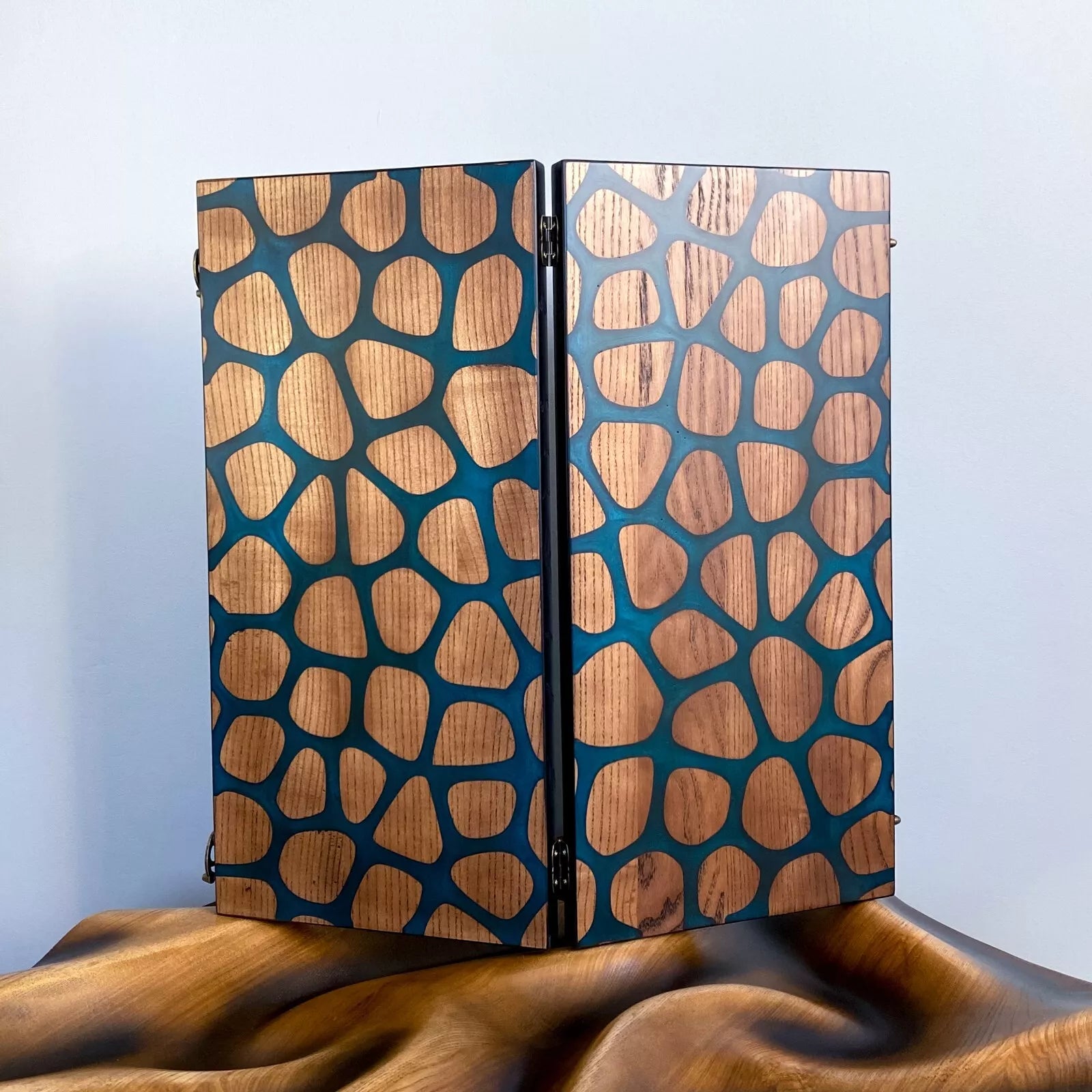 Handcrafted wooden backgammon board with abstract giraffe-pattern resin inlay in blue and natural wood tones.