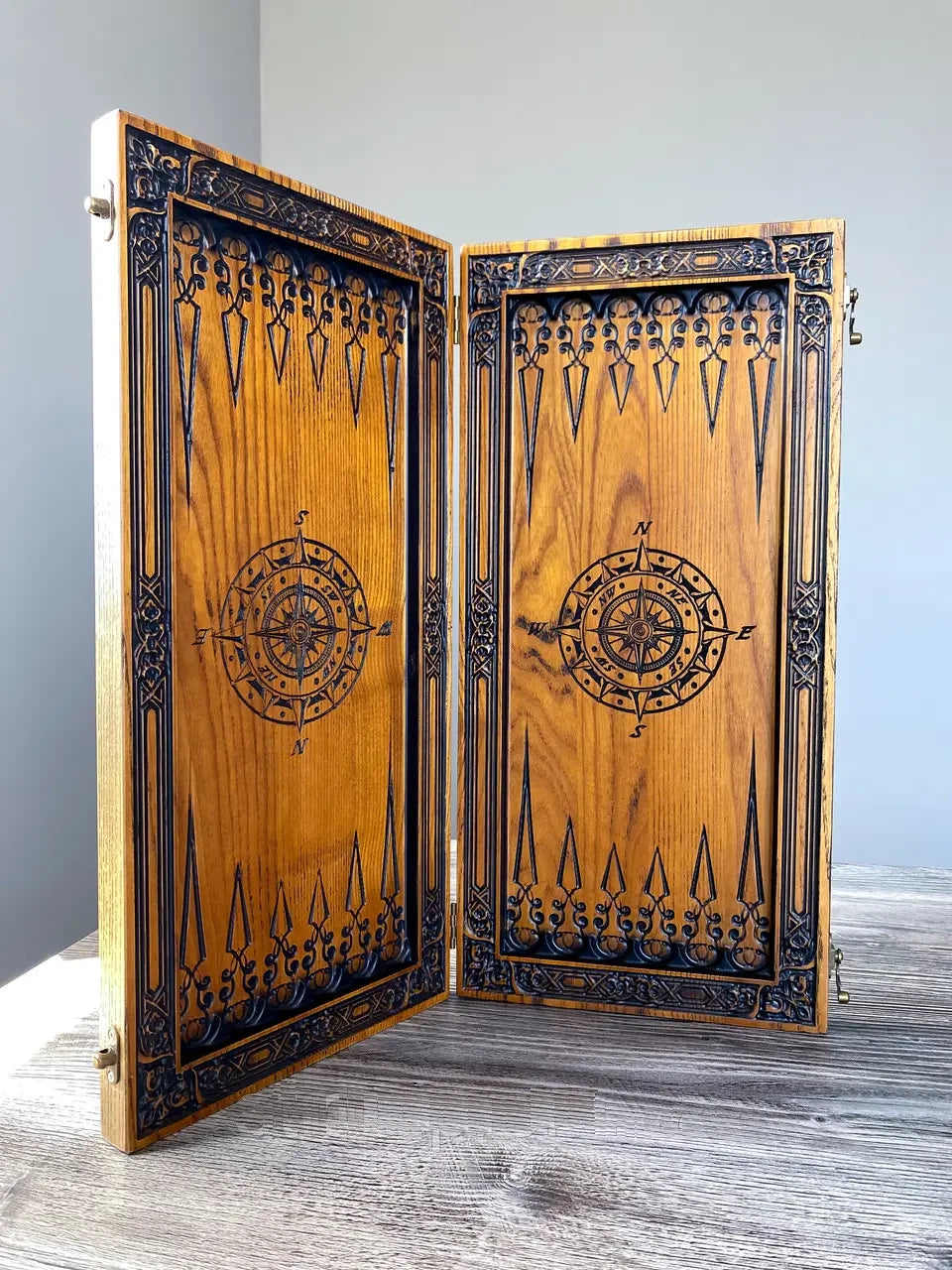 Backgammon set opened to show engraved compass artwork and detailed wooden craftsmanship.