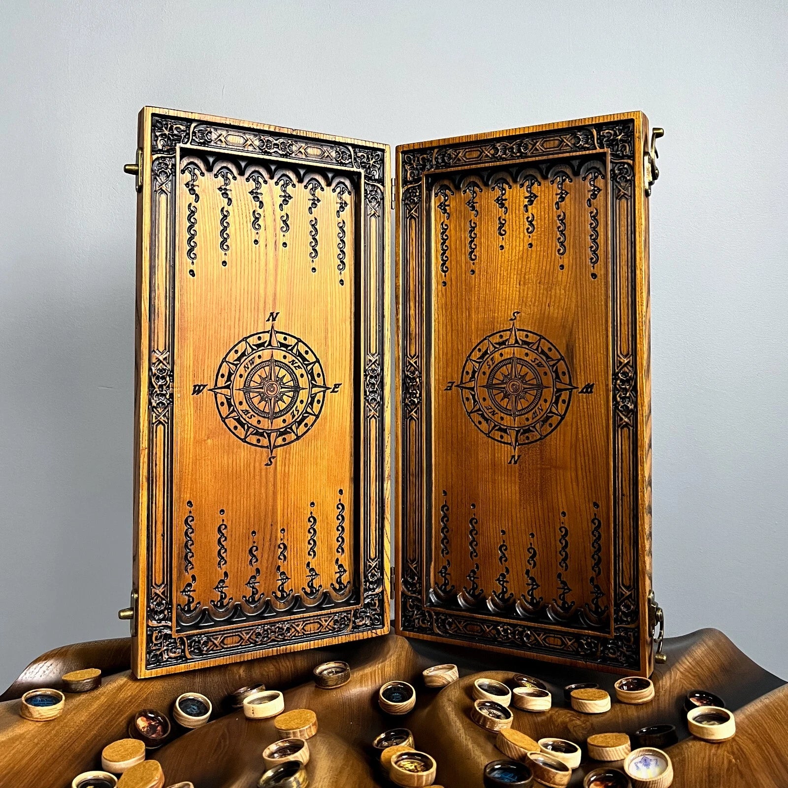Handcrafted compass-themed backgammon set featuring yellow and silver checkers on an engraved wooden board.