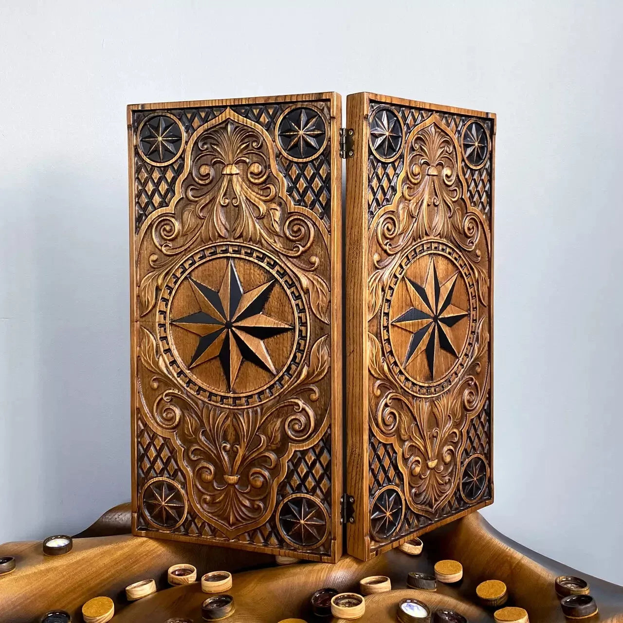 Carved ash wood backgammon case featuring detailed compass star design and intricate ornamental motifs.