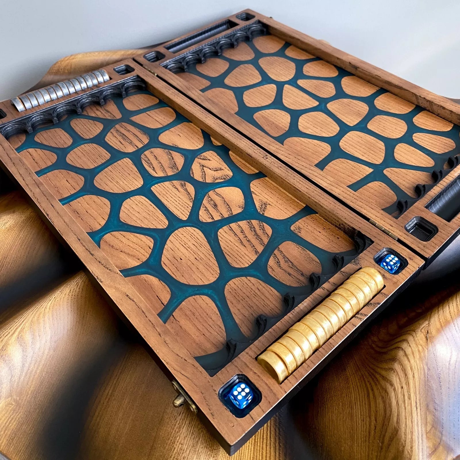 Open backgammon board with blue resin giraffe-pattern inlay, metal checkers, and blue dice.