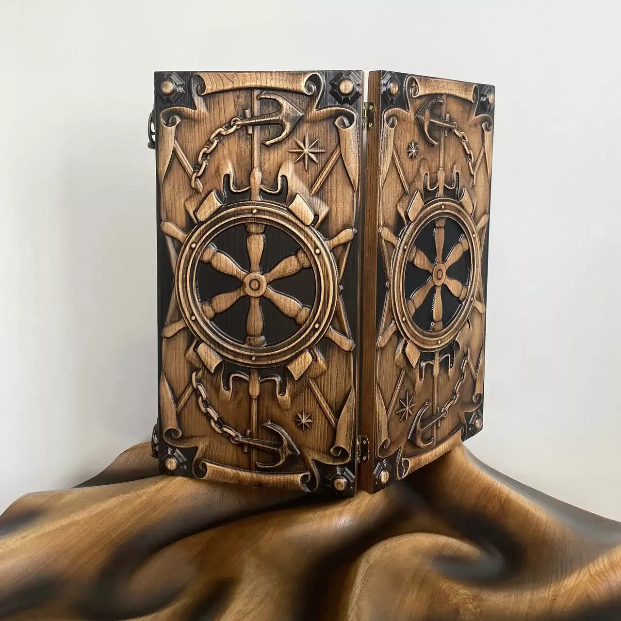 Hand-carved wooden backgammon set with ship wheel and anchor design on the exterior.