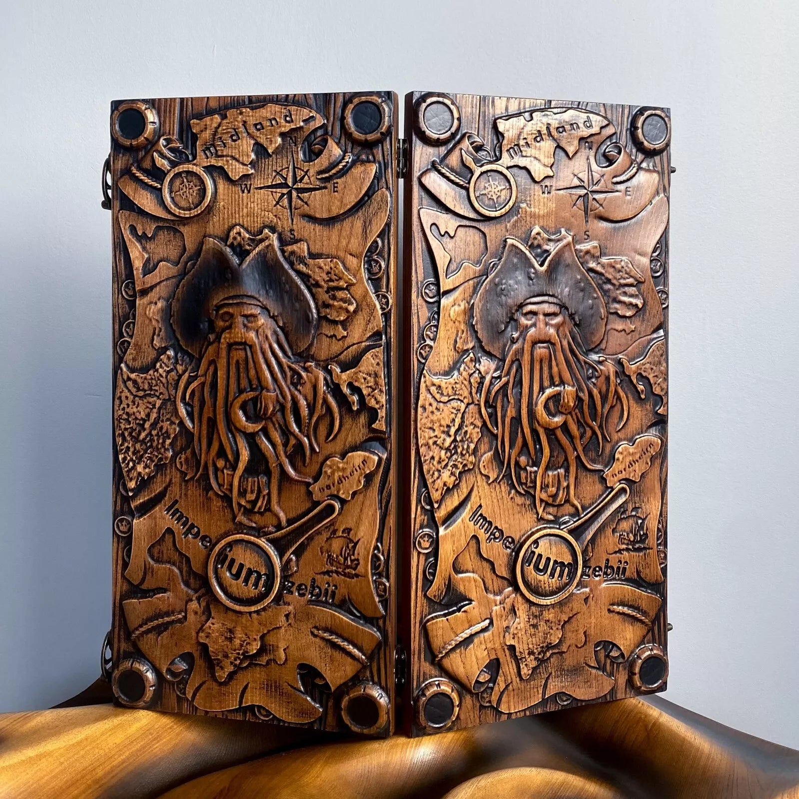 Carved wooden backgammon board featuring a pirate figure with nautical map and compass details in a fantasy theme.