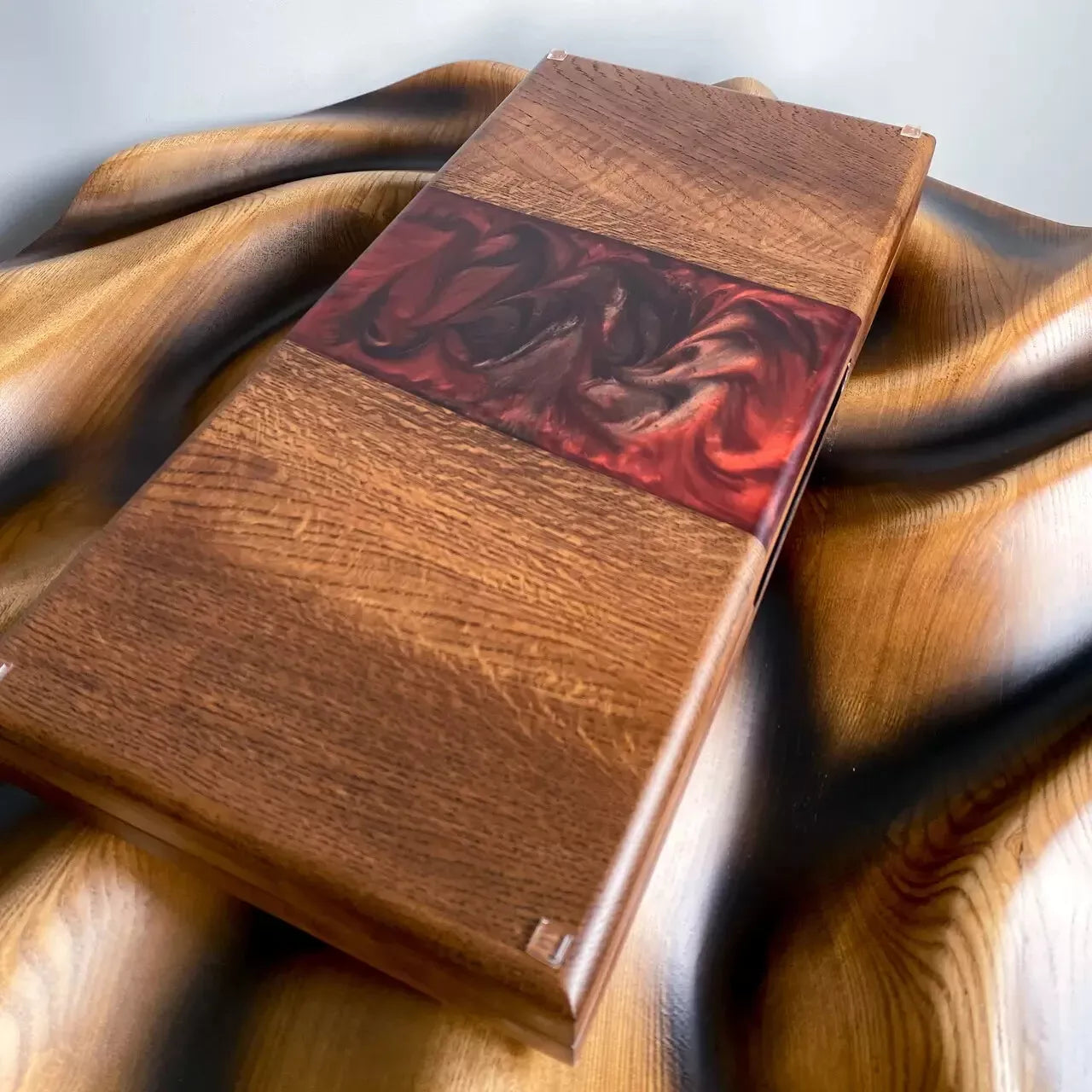 Close-up of epoxy river backgammon set showing natural wood grain and red resin flow