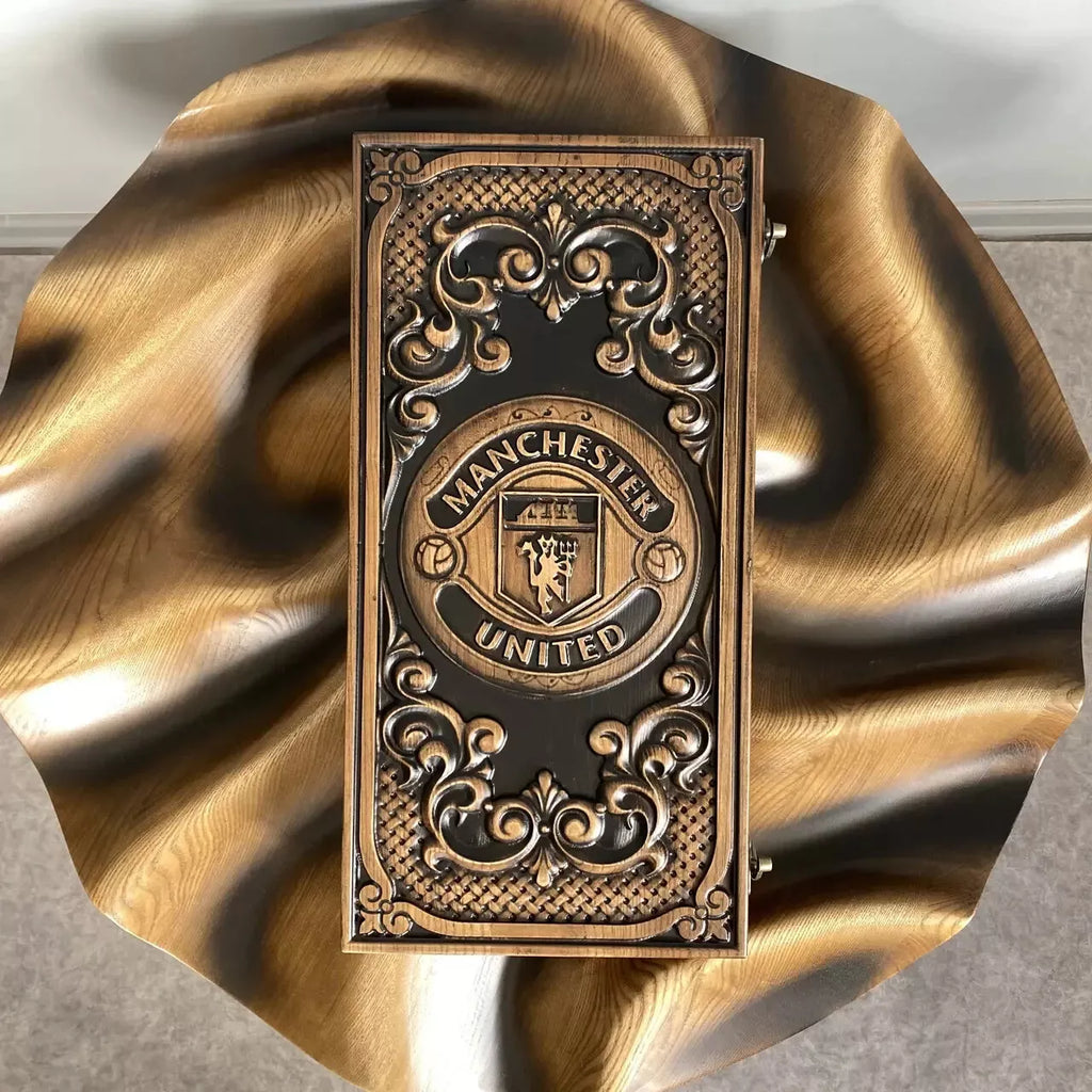 Hand-carved wooden backgammon set with Manchester United emblem, top view of closed board on natural wood background