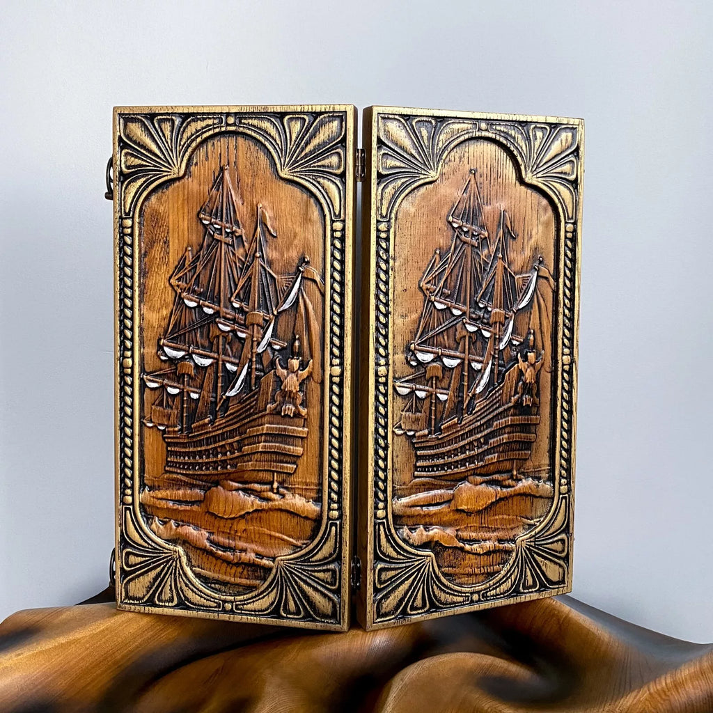 Hand-carved wooden backgammon board with an intricate sailing ship design on the front panel.