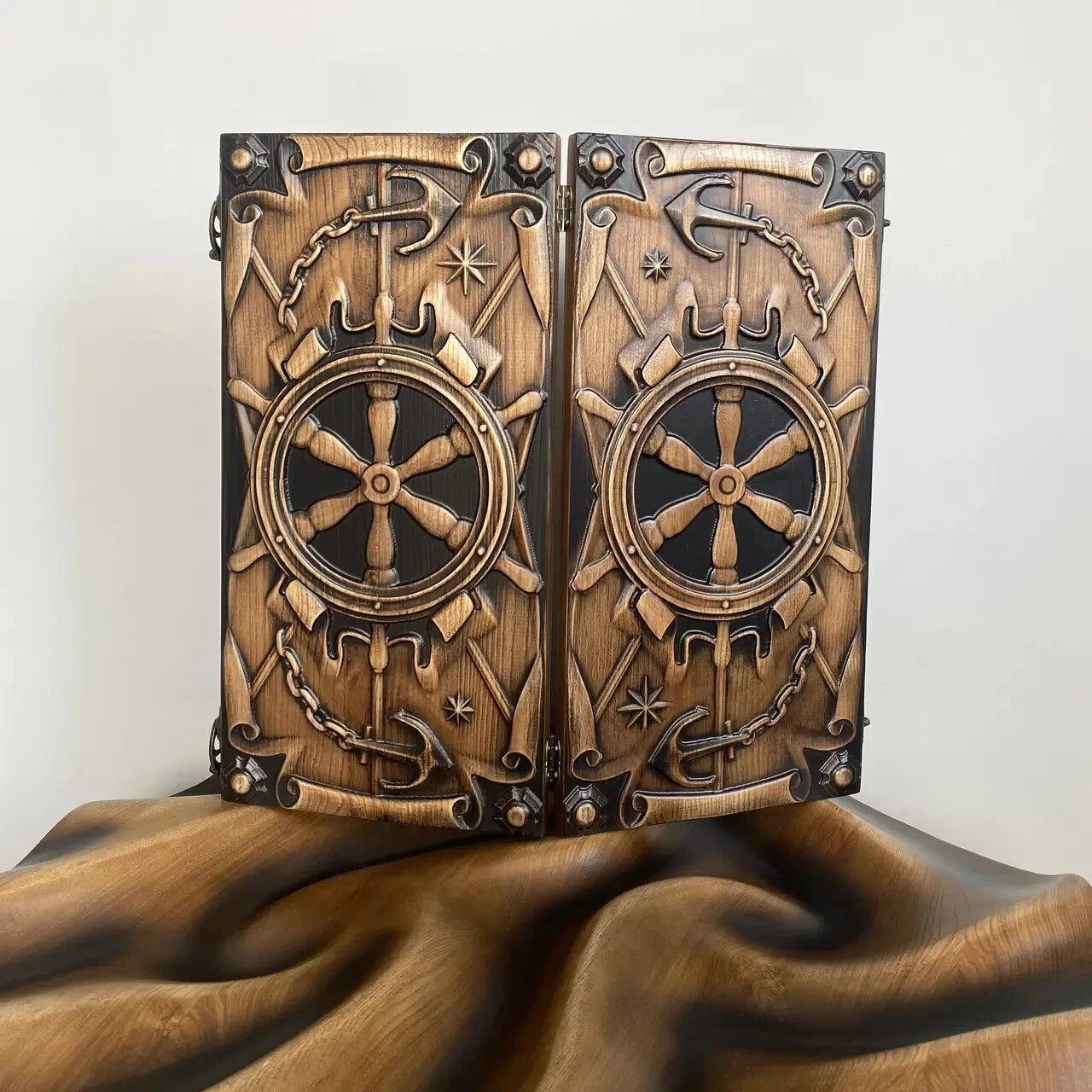 Hand-carved wooden backgammon set with ship wheel and anchor design on the exterior.